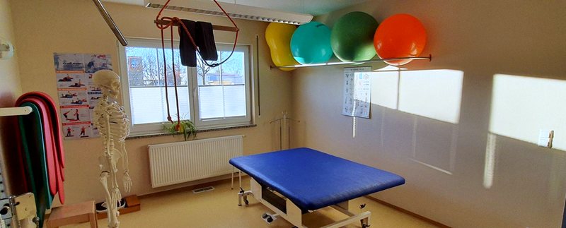 Therapieraum mit Gymnastikbällen, Therabändern und Behandlungsliege